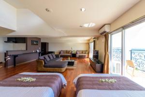 a hotel room with two beds and a living room at Condominium Hotel Monpa in Chatan