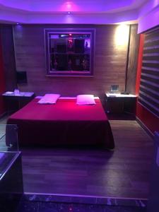 ブエノスアイレスにあるHotel Gildaのベッドルーム1室(紫色の照明が付いた大型ベッド1台付)