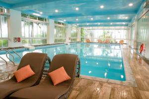 a large swimming pool with chairs in a building at Ninh Binh Legend Hotel in Ninh Binh