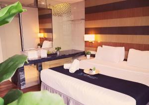 a hotel room with two beds and a mirror at D'majestic Place By Homes Asian 03 in Kuala Lumpur