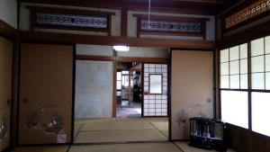 einen Flur in einem Gebäude mit Türen und Fenstern in der Unterkunft HACHI in Ōdate