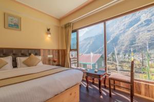 a bedroom with a bed and a large window at Magellan's The Golden Bridge in Lachung