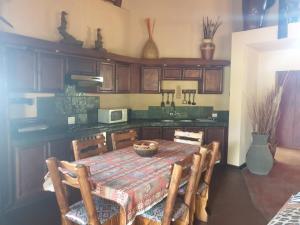 a kitchen with a table and chairs and a kitchen with a counter at Makhato Bush Lodge 17 in Bela-Bela +12 photos