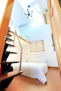 a bedroom with a bed and a spiral staircase at Water 168 Homestay in Xiaoliuqiu