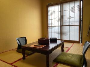 une pièce avec une table, des chaises et une fenêtre dans l'établissement Umimoto, à Hakone 137 autres photos