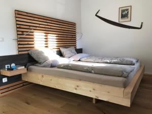 ein Bett mit einem Holzrahmen in einem Zimmer in der Unterkunft mein Quartier in Oberammergau