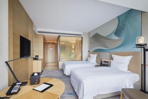 Habitación de hotel con 2 camas y escritorio en Pullman Shanghai Qingpu Excellence en Shanghái