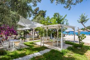 a group of tables and chairs under a canopy on the beach at Limnonari Split Level Studio in Skopelos Town