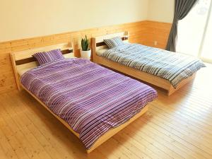two beds sitting next to each other in a room at HIBARI GUESTHOUSE in Sendai
