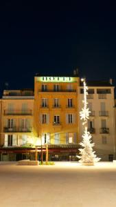a hotel building with a christmas tree in front of it at Hotel Relais Du Postillon in Antibes