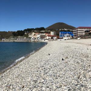 a rocky beach with buildings in the background at Kavkaz Hotel in Olginka