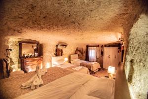 a bedroom with two beds in a cave at Kamelya Cave Hostel in Göreme