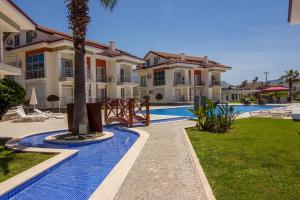 a villa with a swimming pool and a resort at Körfez Garden Apartments in Fethiye