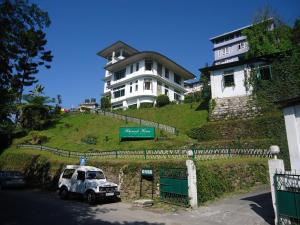 a white truck parked in front of a large house at Rhenock House (a luxury villa) in Gangtok