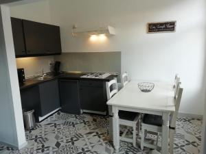 a kitchen with a table and a white table and chairs at L'appart promenade de 4 heures in Spa