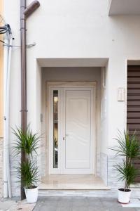 una puerta delantera de una casa blanca con dos macetas en Casa Marconi Ribera, en Ribera