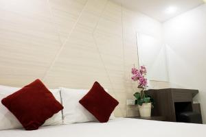 a bedroom with a bed with two red pillows at DB PLUS 6 in Bangkok