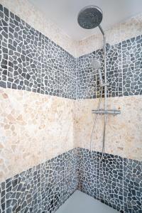 a bathroom with a shower with blue and white tiles at Arcadia - Péniche de Standing à Namur avec vue sur la Citadelle in Namur