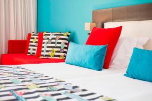 a hotel room with two beds with colorful pillows at Skiathos Palace Hotel in Koukounaries