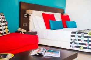 a bedroom with a bed with red and blue pillows at Skiathos Palace Hotel in Koukounaries
