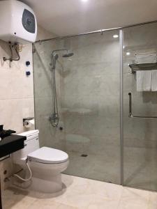 a bathroom with a glass shower with a toilet at Tung Duong Hotel in Thái Nguyên