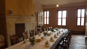 uma sala de jantar com uma mesa longa e cadeiras em Lindstedter Gutsstuben em Gardelegen