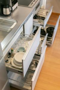 an open kitchen drawer with plates and dishes in it at 白馬パウダーマウンテン in Hakuba