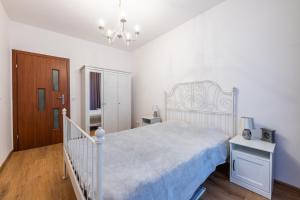 ソポトにあるVictus Apartamenty, Apartament Cadena 2の白いベッドルーム(白いベッド1台、シャンデリア付)