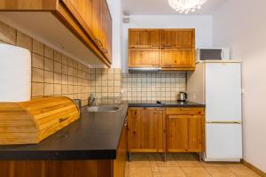 ソポトにあるVictus Apartamenty, Apartament Cadena 2のキッチン(木製キャビネット、白い冷蔵庫付)
