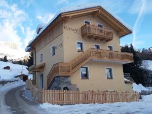 ein Gebäude mit einem Balkon auf der Seite in der Unterkunft Blizzard apartments in Arabba