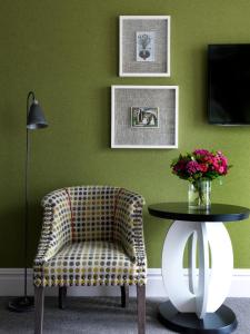 a living room with a couch, chair and a vase of flowers at Dorset Square Hotel, Firmdale Hotels in London