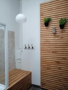 un baño con una pared de madera con dos plantas. en Hostal Rama & CaStle, en Valparaíso