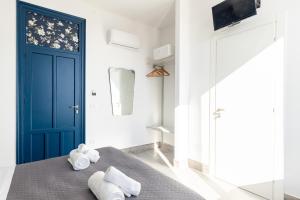 a bedroom with a blue door and towels on a bed at Villa Edera Rental Room in Santa Flavia +148 photos