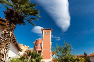 a white cloud in the sky above a clock tower at Villa Edera Rental Room in Santa Flavia