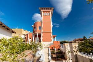 a building with a clock tower on top of it at Villa Edera Rental Room in Santa Flavia