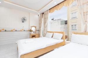 two beds in a room with a window at MOTEL THỦY TIÊN in Vung Tau