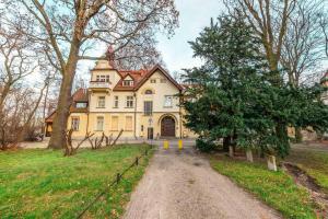 a large yellow house on a dirt road at Victus Apartamenty Apartament Bolek i Lolek in Sopot