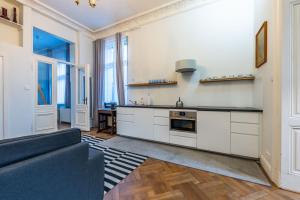 ソポトにあるVictus Apartamenty Apartament Bolek i Lolekの白いキャビネットとソファ付きのキッチンが備わります。