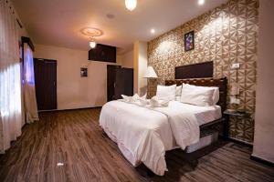 sypialnia z dużym łóżkiem z białą pościelą w obiekcie Creek Hotel w mieście Panaji