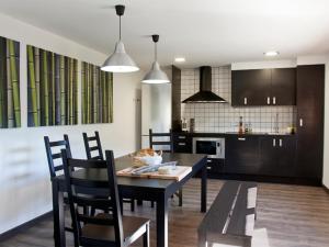 a kitchen and dining room with a table and chairs at Mas Pinoses in Les Llosses