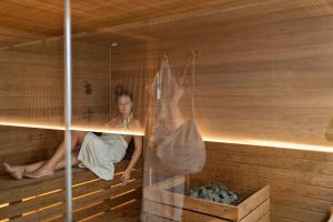 a woman in a sauna with a person sitting in it at Posia Retreat & Spa UNA Esperienze in San Foca