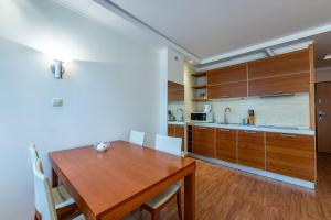 ソポトにあるGlow Apartments, Apartament Meriwa Sopotのキッチン、ダイニングルーム(木製のテーブルと椅子付)