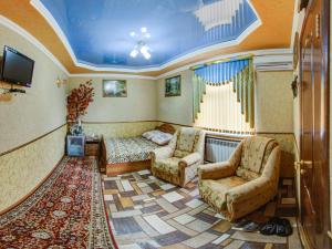 a living room with a bed and two chairs at Hotel ARS (АРС) in Saratov