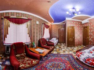 a room with red chairs and a bed and a rug at Hotel ARS (АРС) in Saratov