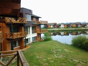 una casa con un lago delante de ella en Villa Amancay Lake en Dina Huapi