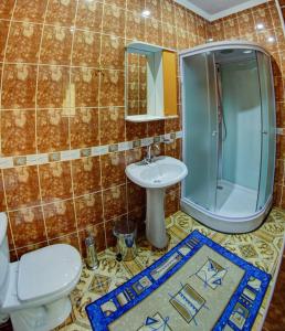 a bathroom with a toilet and a sink and a shower at Hotel ARS (АРС) in Saratov