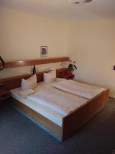 ein Schlafzimmer mit einem großen Bett in einem Zimmer in der Unterkunft Gasthof Alte Post in Bischofsmais