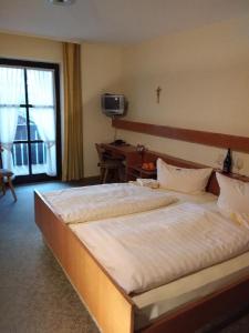 a bedroom with a large white bed with a window at Gasthof Alte Post in Bischofsmais