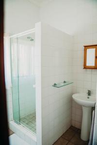 a bathroom with a glass shower and a sink at Port Edward Holiday Resort in Port Edward