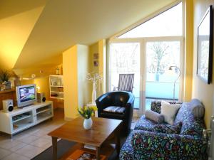 a living room with a couch and a tv at Apartments Sonnendeck in Warnemünde